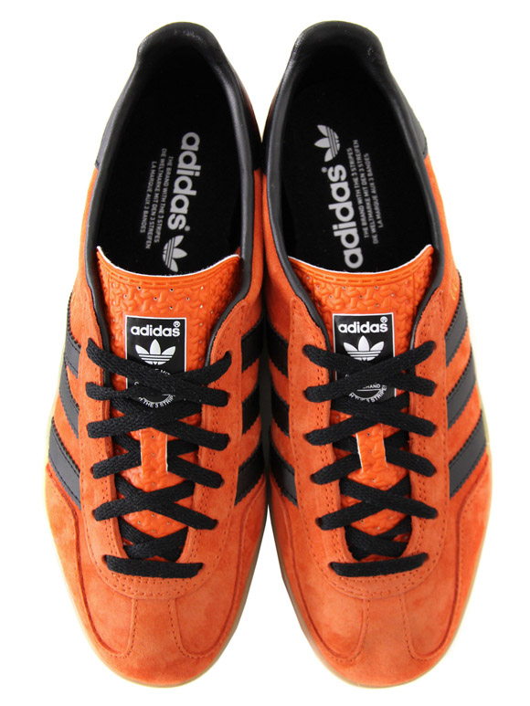 black adidas trainers with orange stripes