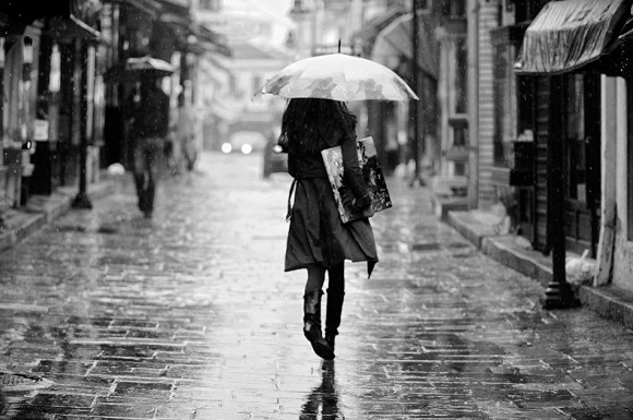 Mario Davchevski, Classy Woman in Rain Boots carrying painting under her arm under an Umbrella