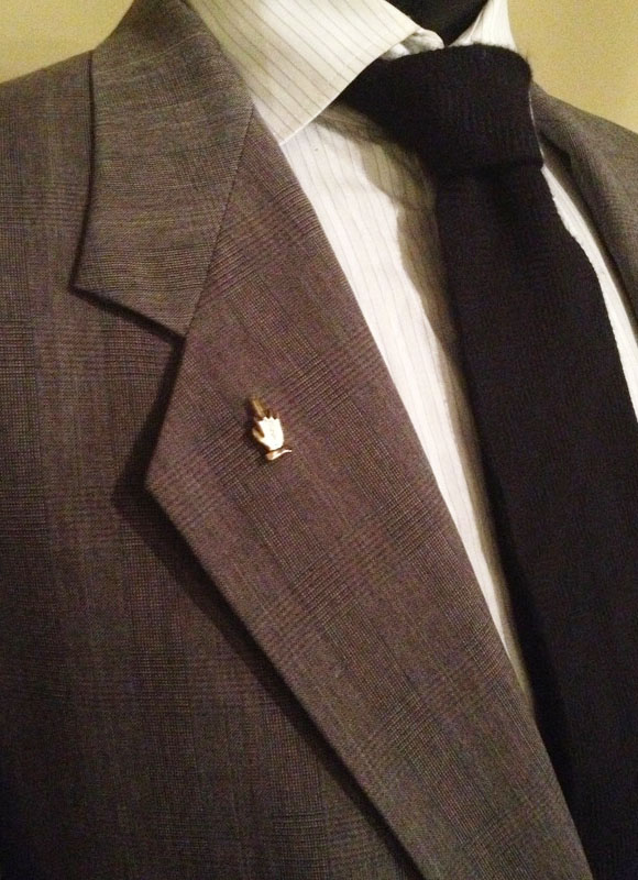 Fifth & Melrose Middle Finger Lapel pin on suit